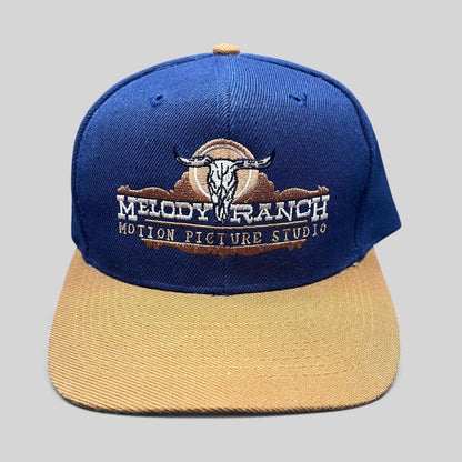 Raree Finds vintage Melody Ranch Motion Picture Studio navy and tan snapback hat with embroidered longhorn skull logo.