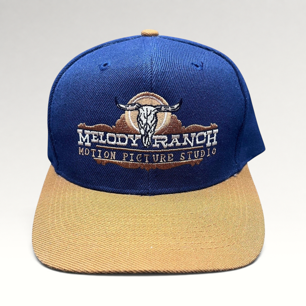 Raree Finds vintage Melody Ranch Motion Picture Studio navy and tan snapback hat with embroidered longhorn skull logo.