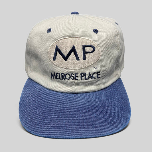 Raree Finds vintage 90s Melrose Place TV promo snapback hat with beige crown, blue brim, and embroidered MP logo.