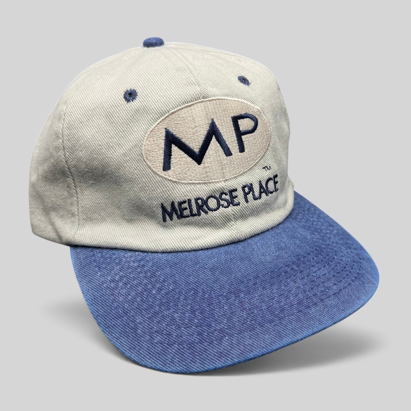 Raree Finds vintage 90s Melrose Place TV show promo snapback hat with beige crown, blue brim, and MP logo embroidery.