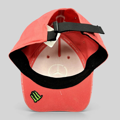 Raree Finds Mercedes AMG Petronas strapback hat in coral pink with Monster Energy logo under the brim and black strap.