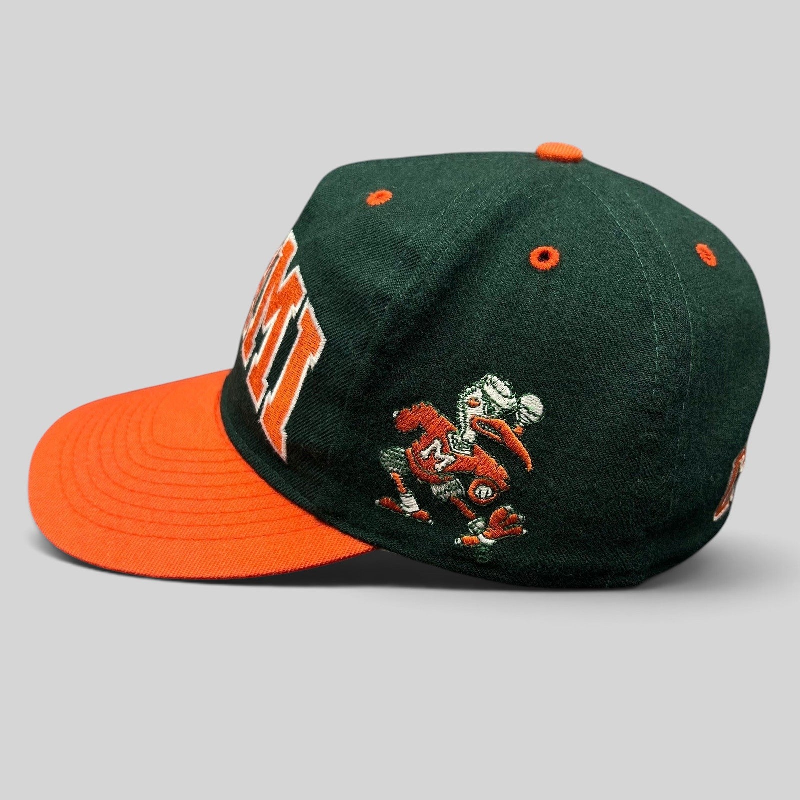 Raree Finds vintage Miami Hurricanes fitted hat with green wool crown, orange brim, and embroidered team mascot.
