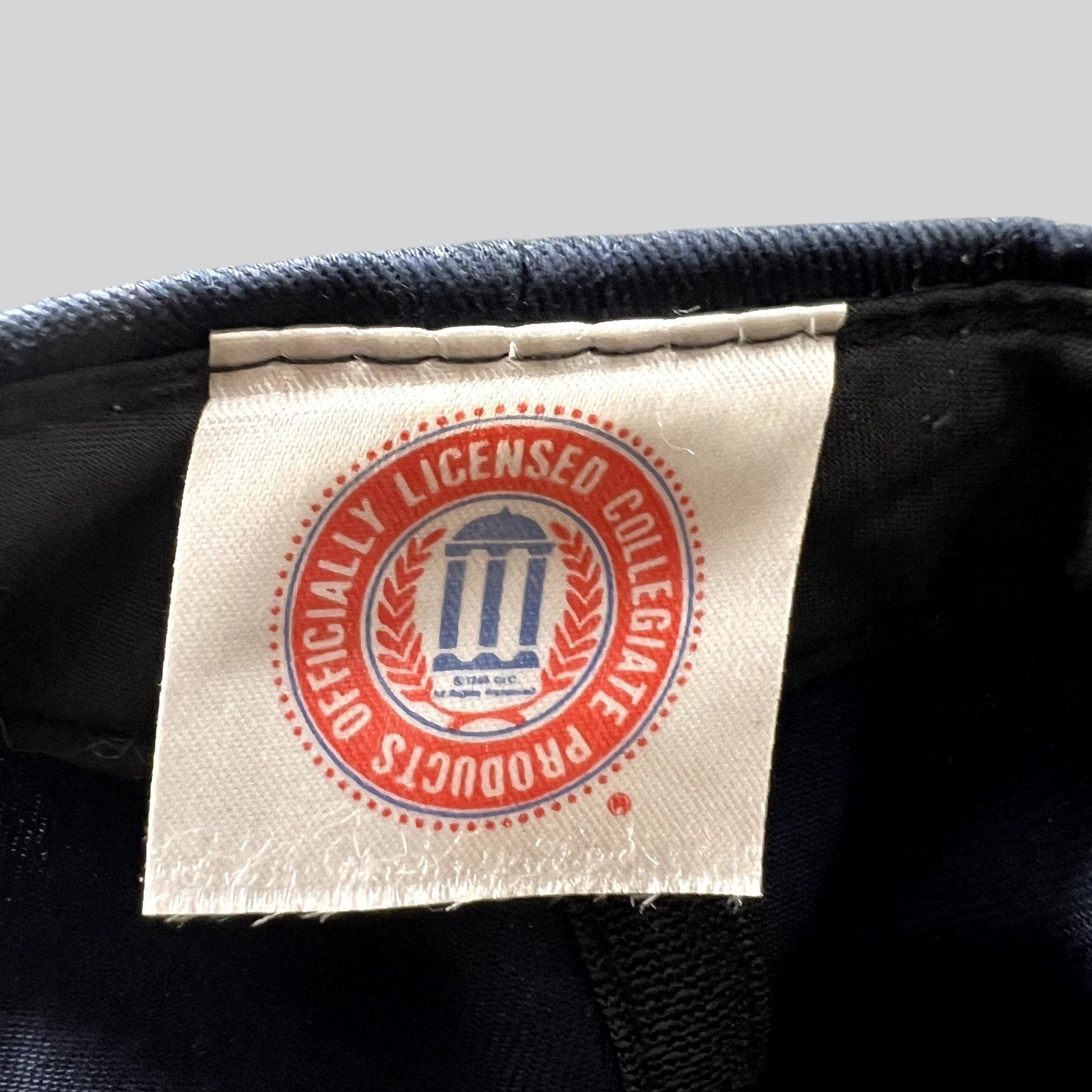 Raree Finds vintage Michigan Wolverines hat interior tag showing the Officially Licensed Collegiate Products logo