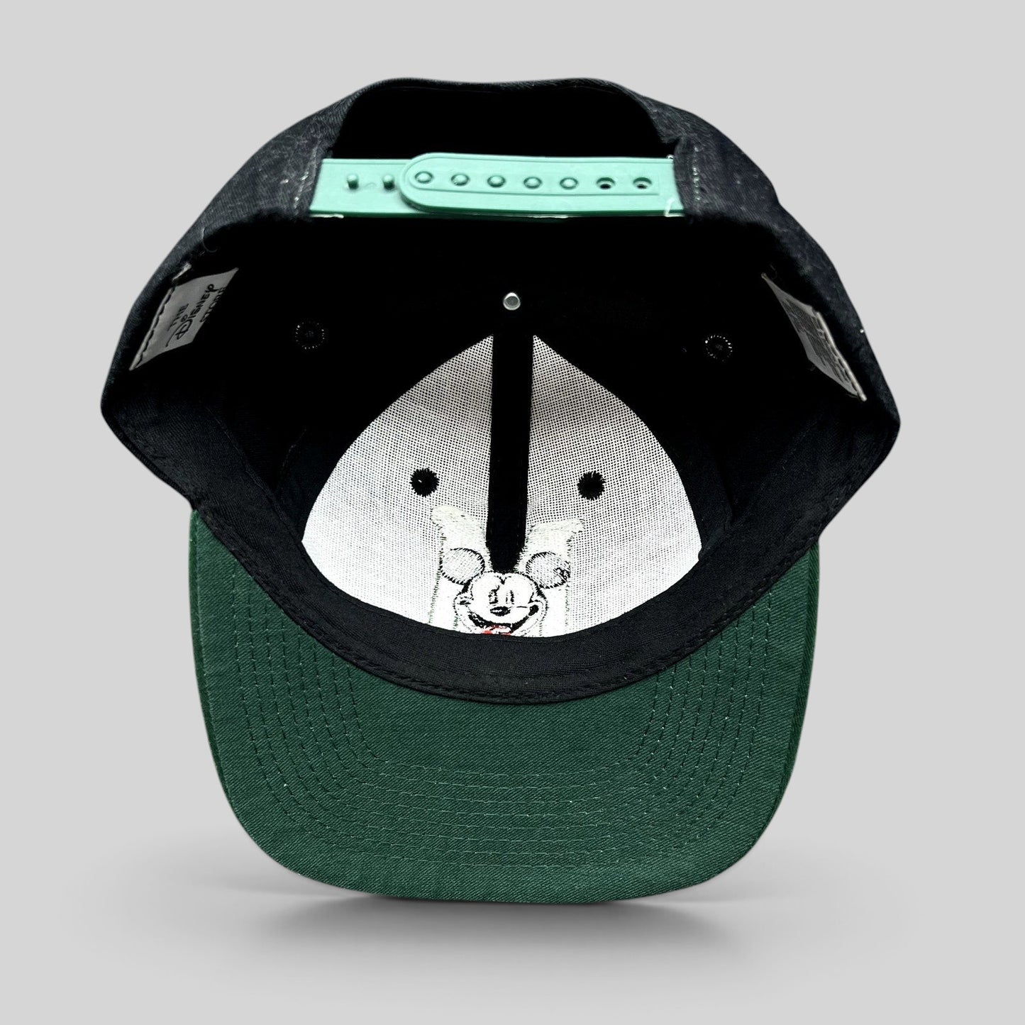 Raree Finds vintage 90s Disney Store Mickey Mouse snapback hat showing the green adjustable closure and green brim