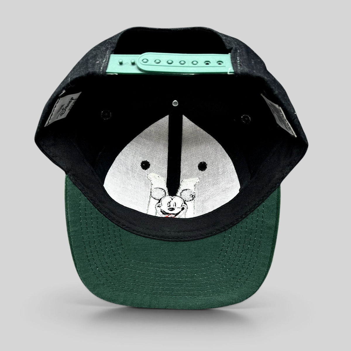 Raree Finds vintage 90s Disney Store Mickey Mouse snapback hat showing the green adjustable closure and green brim