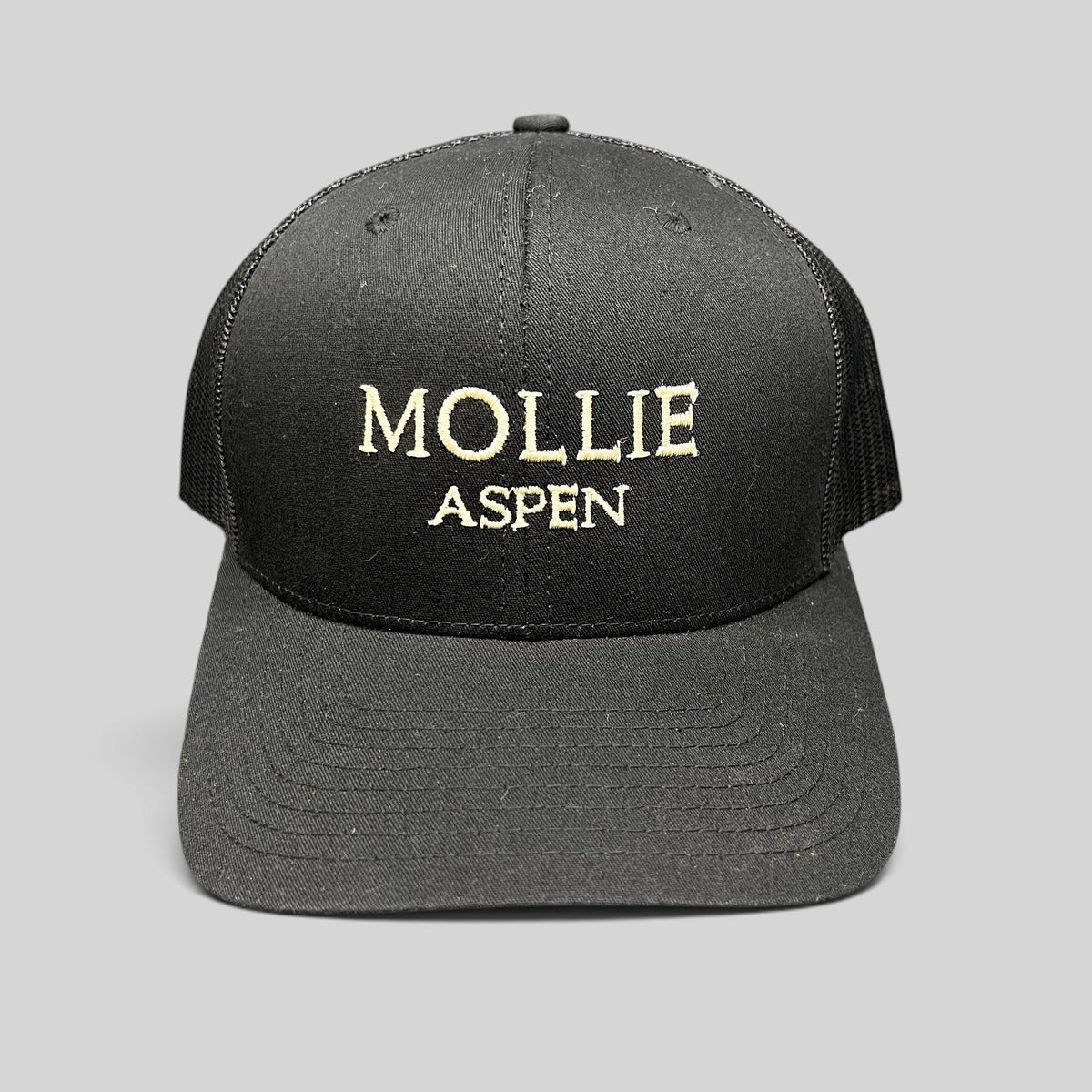 Raree Finds black Yupoong Classics trucker hat with MOLLIE Aspen embroidered logo and breathable mesh back panels