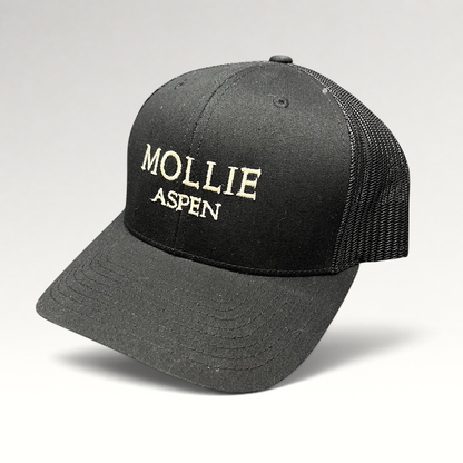 Raree Finds black Yupoong Classics trucker hat with white embroidered MOLLIE Aspen logo and breathable mesh back