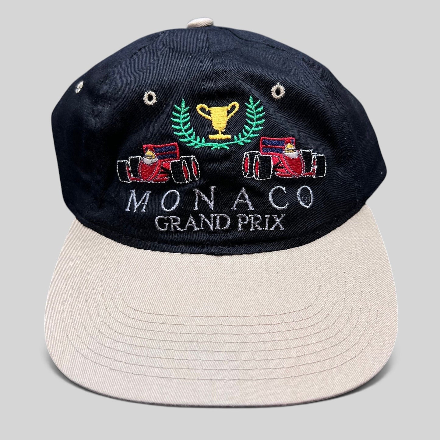 Raree Finds vintage Monaco Grand Prix racing hat with black crown, beige brim, and embroidered F1 race car graphic.