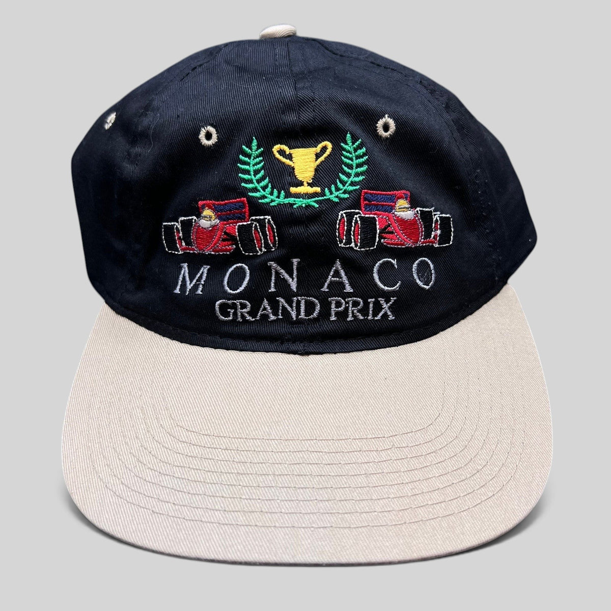 Raree Finds vintage Monaco Grand Prix racing hat with black crown, beige brim, and embroidered F1 race car graphic.