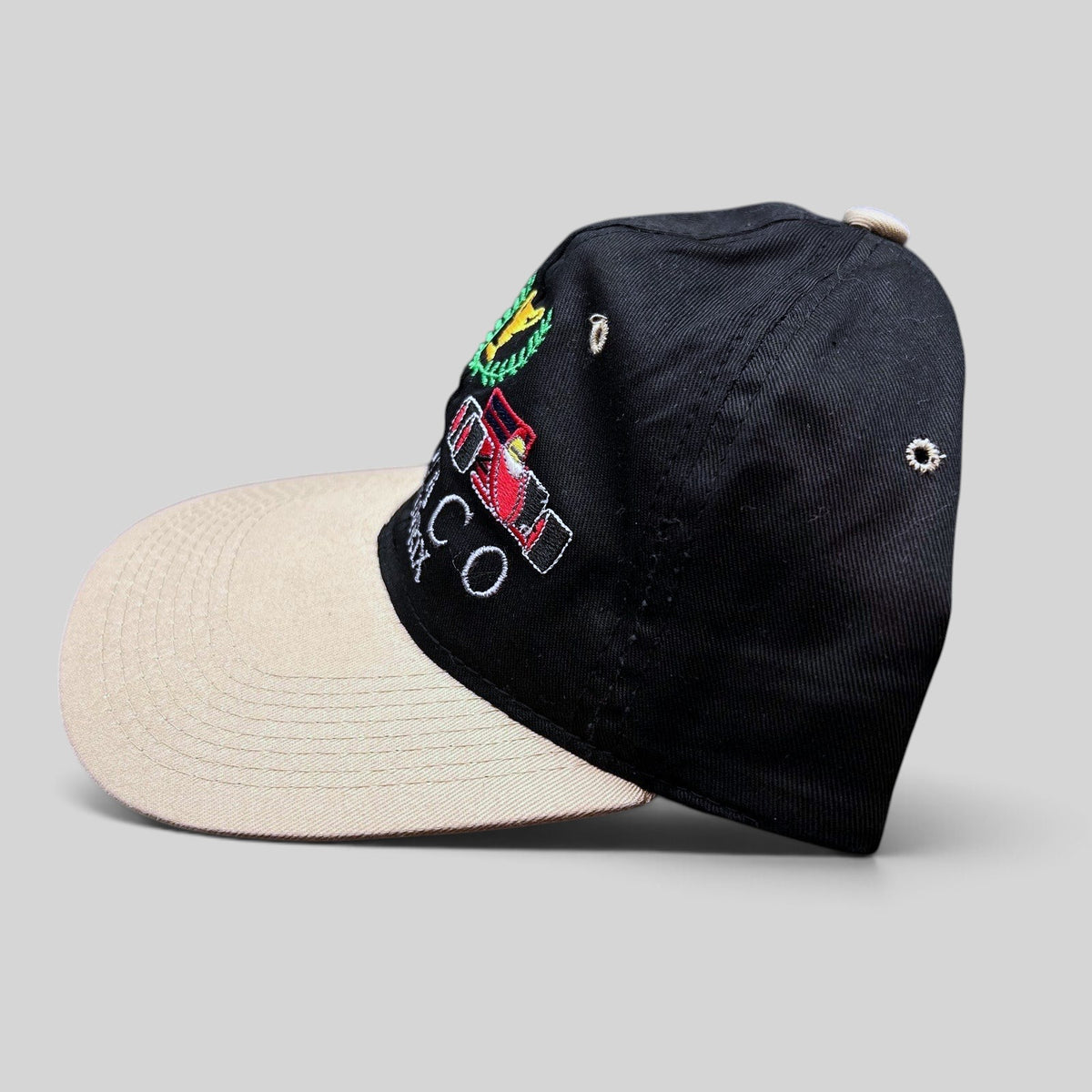 Raree Finds vintage Monaco Grand Prix racing hat with black crown, beige brim, and embroidered Formula One car graphic.
