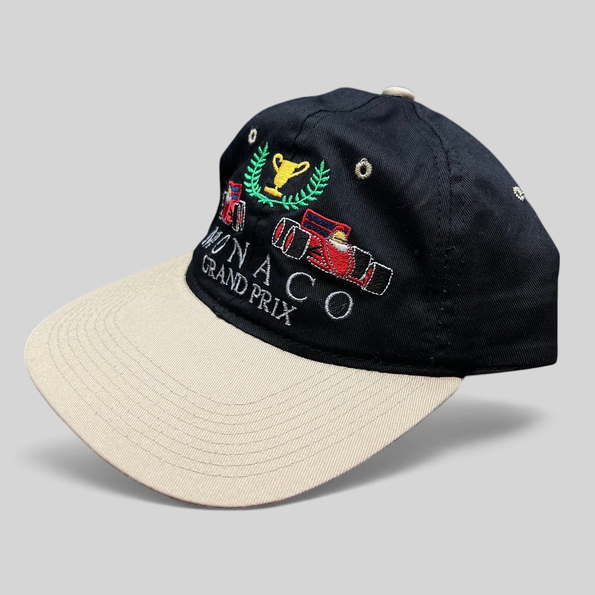 Raree Finds vintage Monaco Grand Prix racing hat with black crown, beige brim, and embroidered Formula One car graphic.