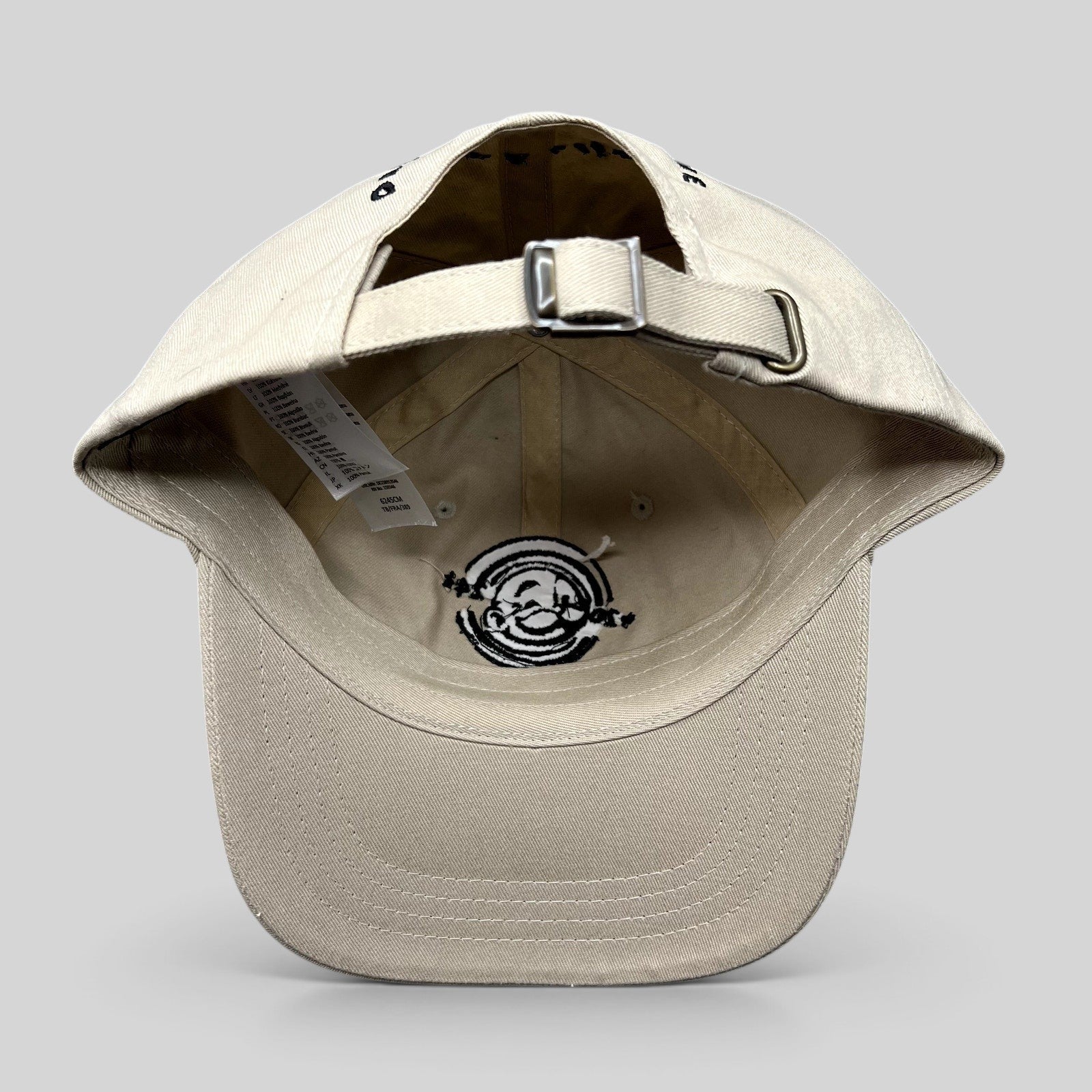 Raree Finds cream Monopoly GO strapback hat with adjustable metal buckle and embroidered interior detail