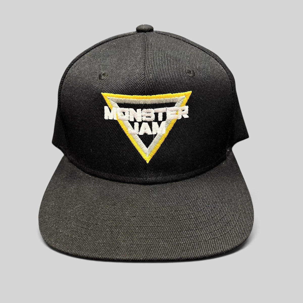 Raree Finds black Monster Jam snapback hat with a white, black, and yellow embroidered triangular logo on the front.