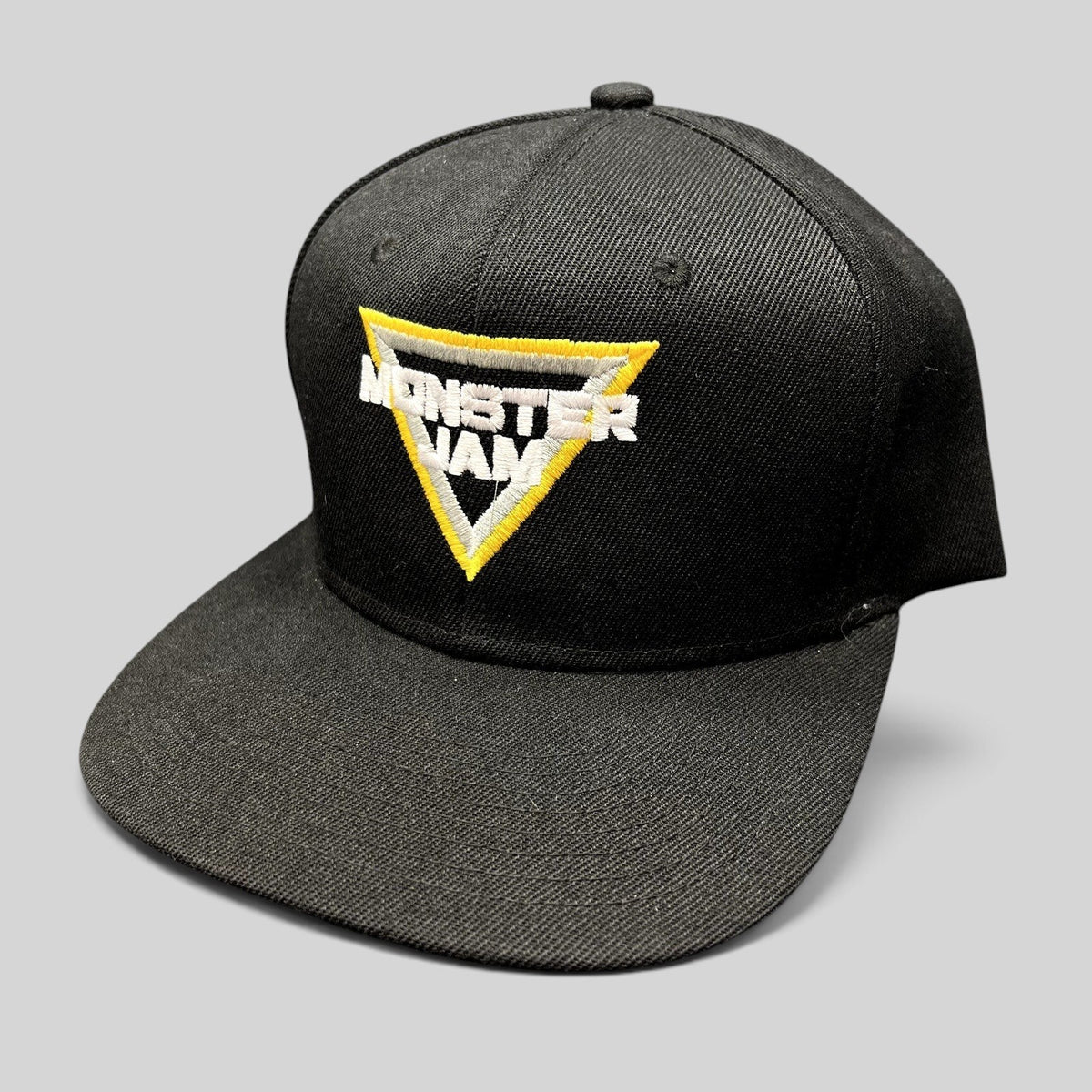 Raree Finds black Monster Jam snapback hat with yellow and white embroidered triangular logo on the front