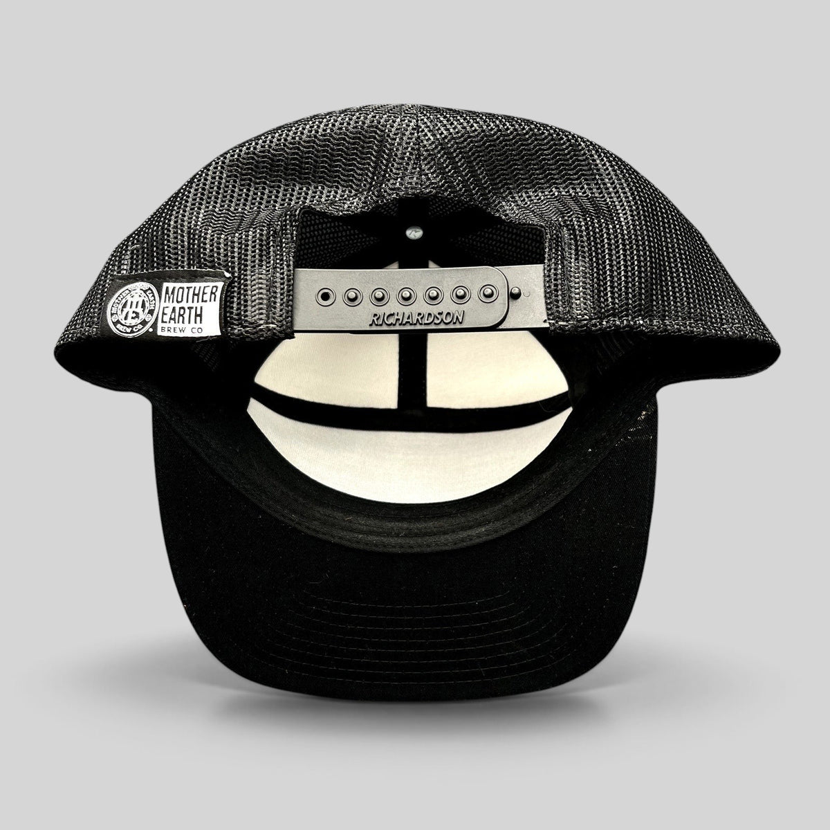 Raree Finds Mother Earth Brew Co Richardson black mesh trucker hat showing the adjustable snapback closure and label