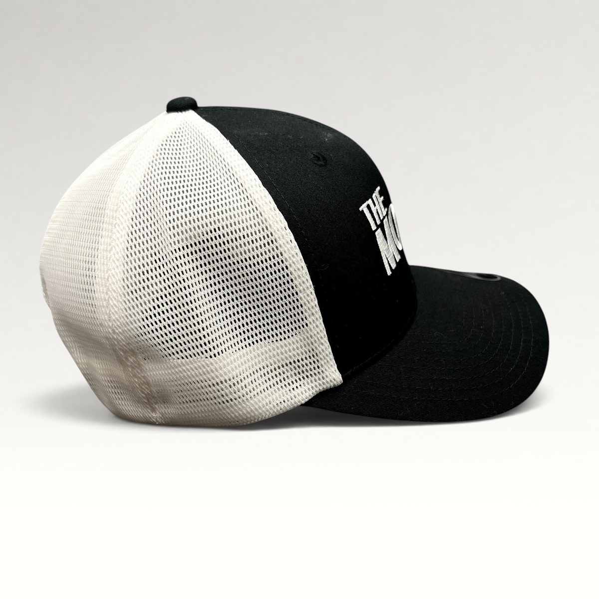 Raree Finds The Movie Guys black and white trucker hat with embroidered logo and breathable mesh back panels