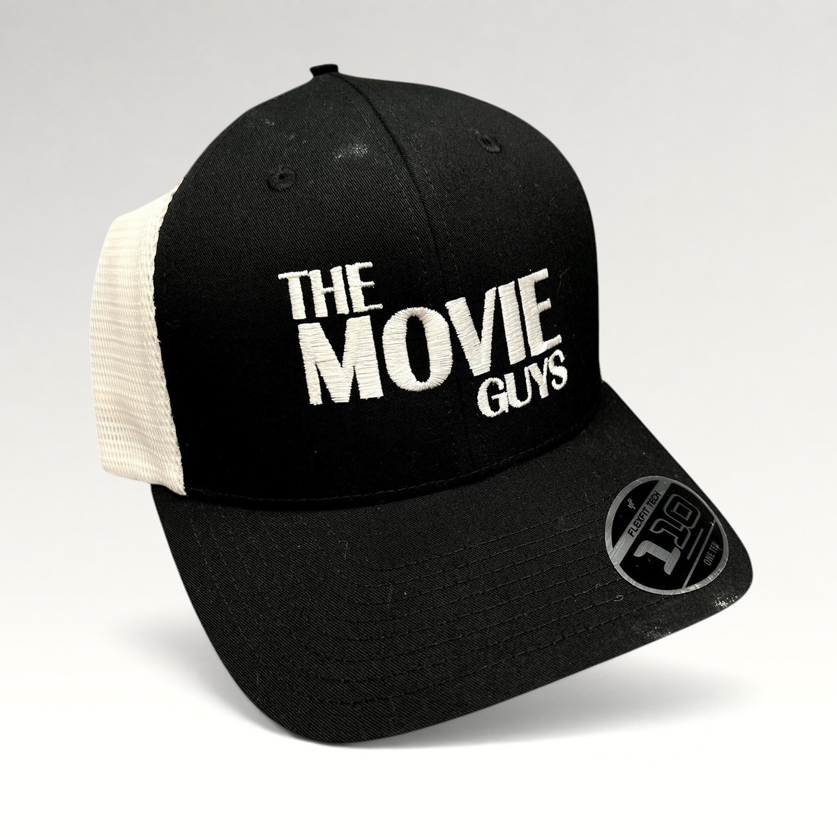 Raree Finds black and white The Movie Guys trucker hat with embroidered logo and breathable mesh back panels.