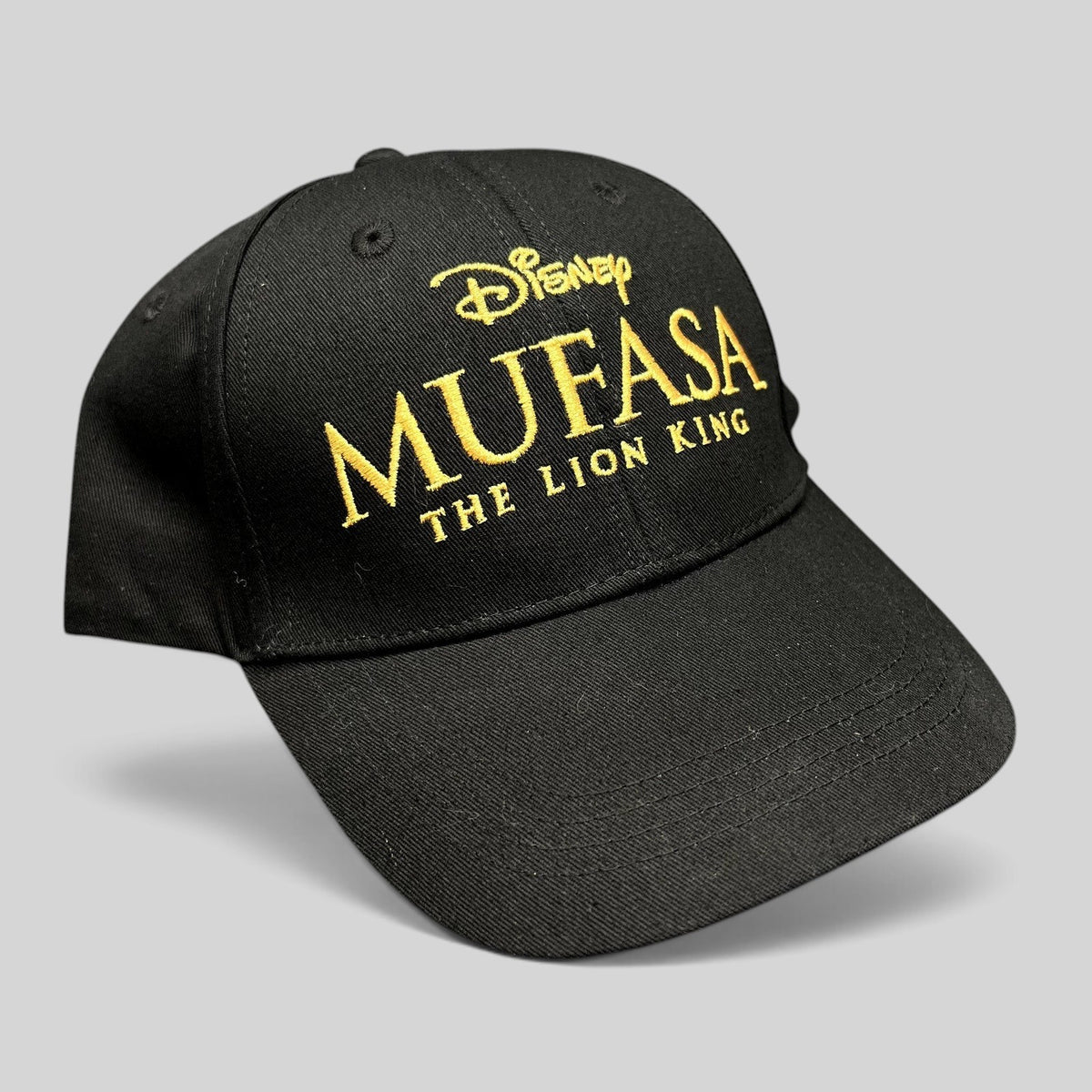 Raree Finds black cotton strapback hat featuring gold embroidered Mufasa The Lion King 2024 movie logo