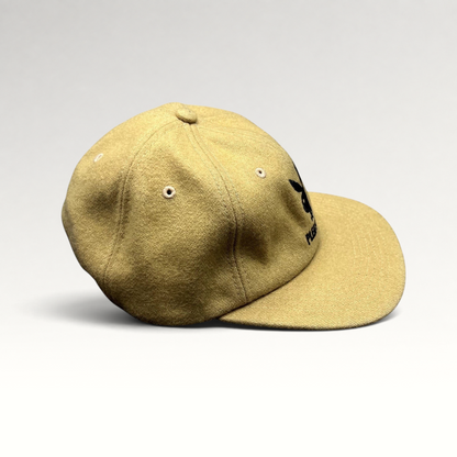 Raree Finds PLEASURES x Playboy mustard wool strapback hat with black embroidered bunny logo and curved brim