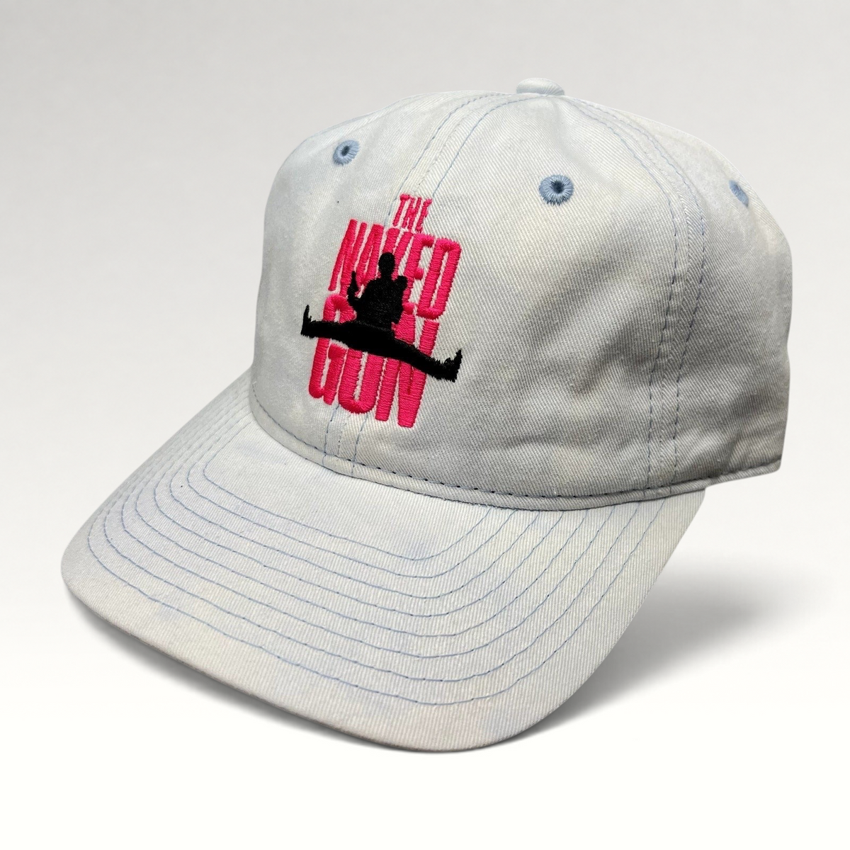 Raree Finds white cotton strapback hat with pink The Naked Gun embroidery and light blue stitching details.