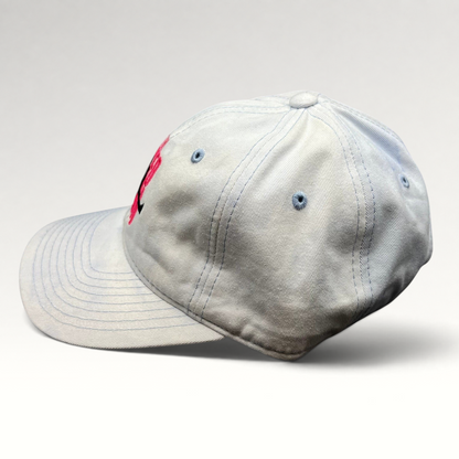 Raree Finds white cotton strapback hat with pink The Naked Gun embroidery and light blue stitching, side profile view.