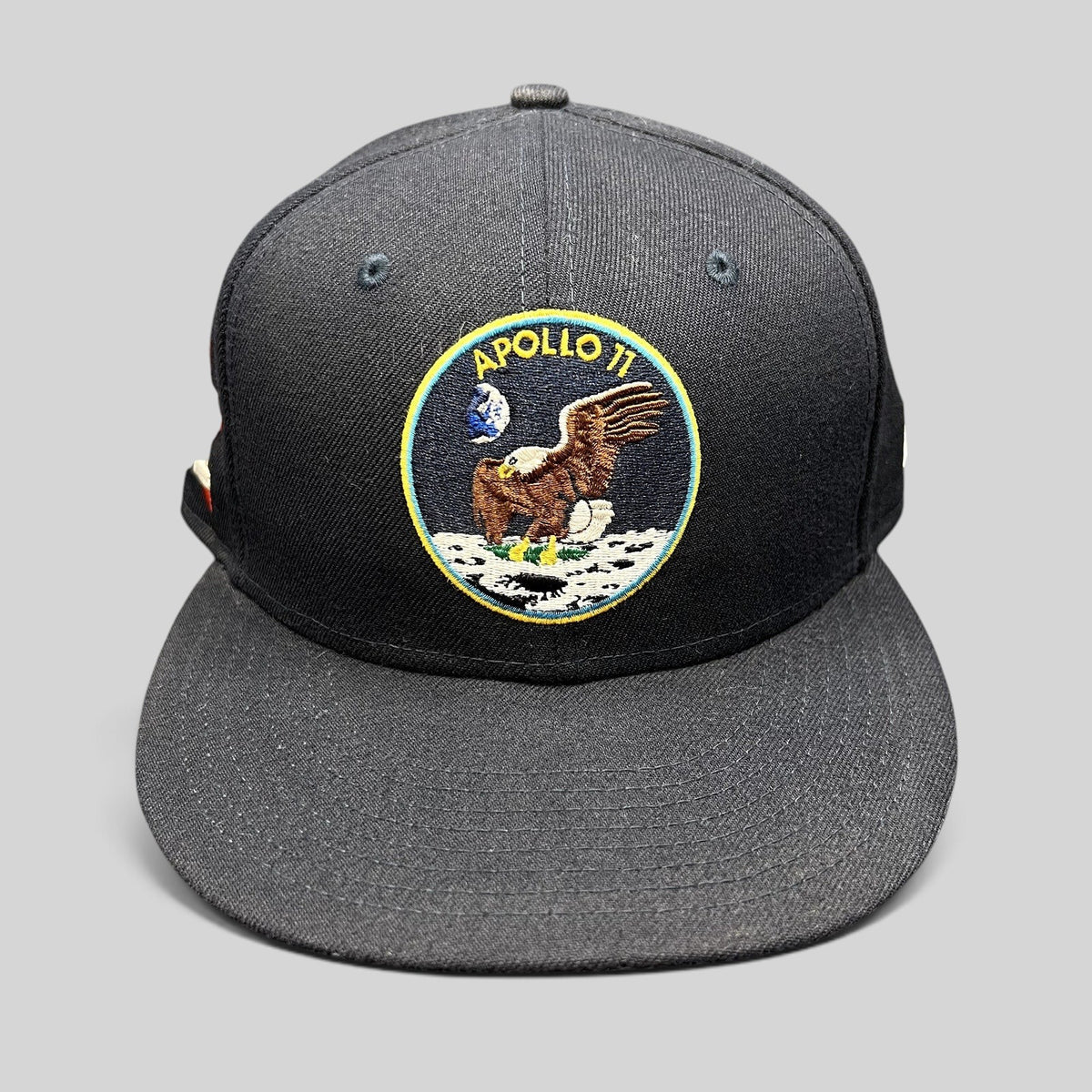 Raree Finds navy blue New Era 59FIFTY fitted hat featuring an embroidered Apollo 11 moon mission patch on the front.