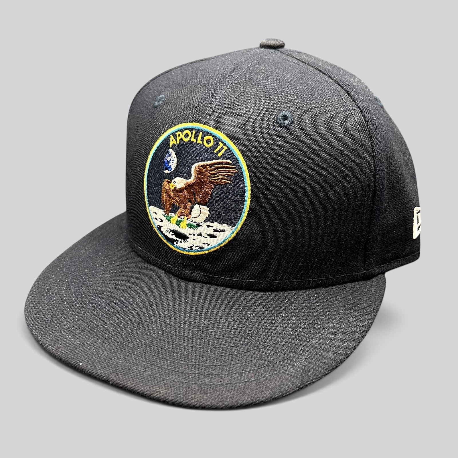 Raree Finds navy blue New Era 59FIFTY fitted hat featuring an embroidered Apollo 11 mission patch on the front.