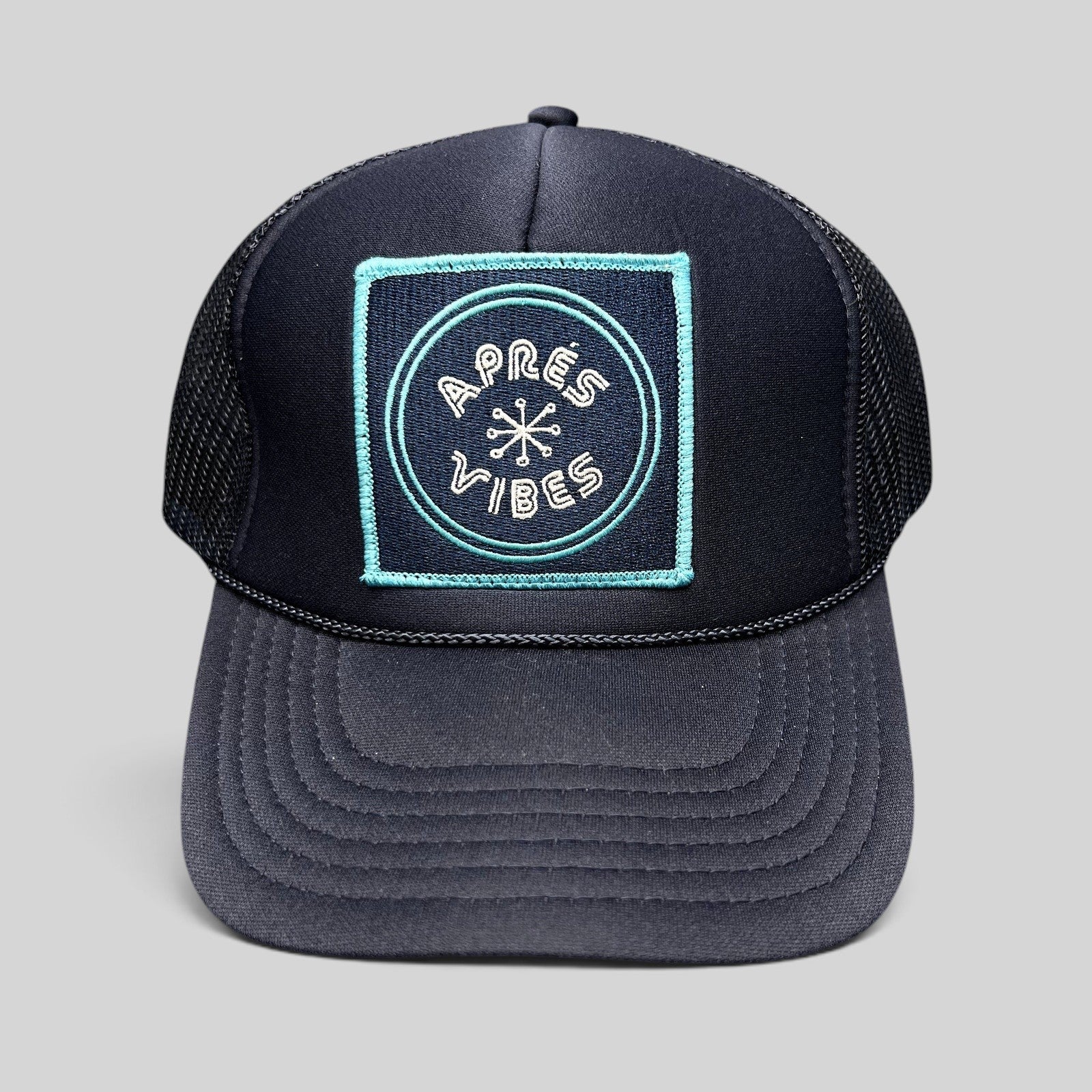 Raree Finds navy blue trucker hat with an Après Vibes embroidered patch, mesh back, and adjustable snapback closure.