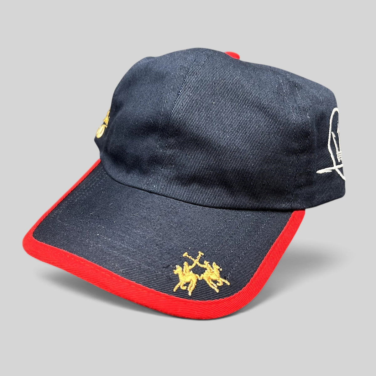 Raree Finds vintage navy blue cotton La Martina polo hat with red brim piping and gold embroidered rider logo