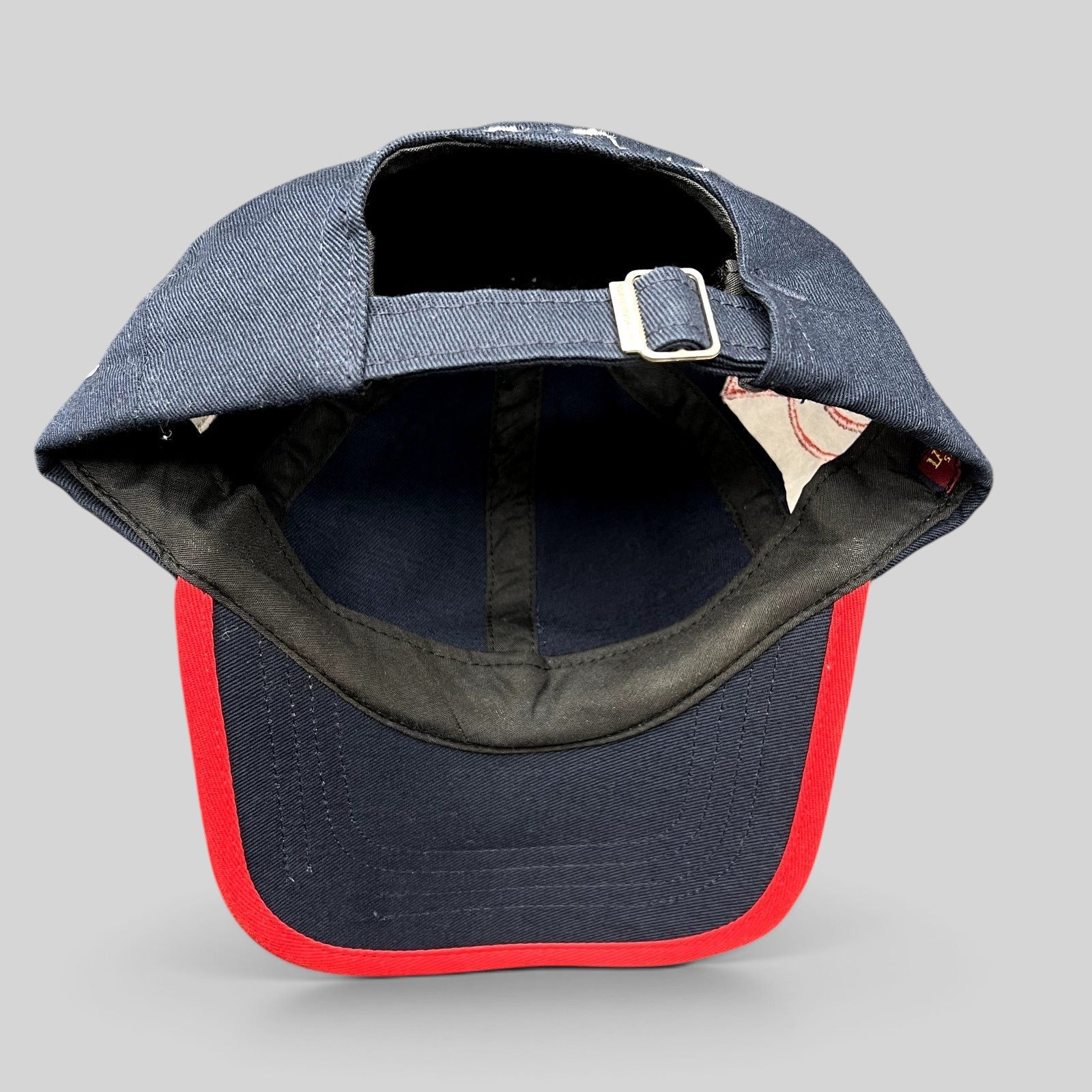 Raree Finds navy blue cotton strapback hat with red brim piping and adjustable metal buckle closure