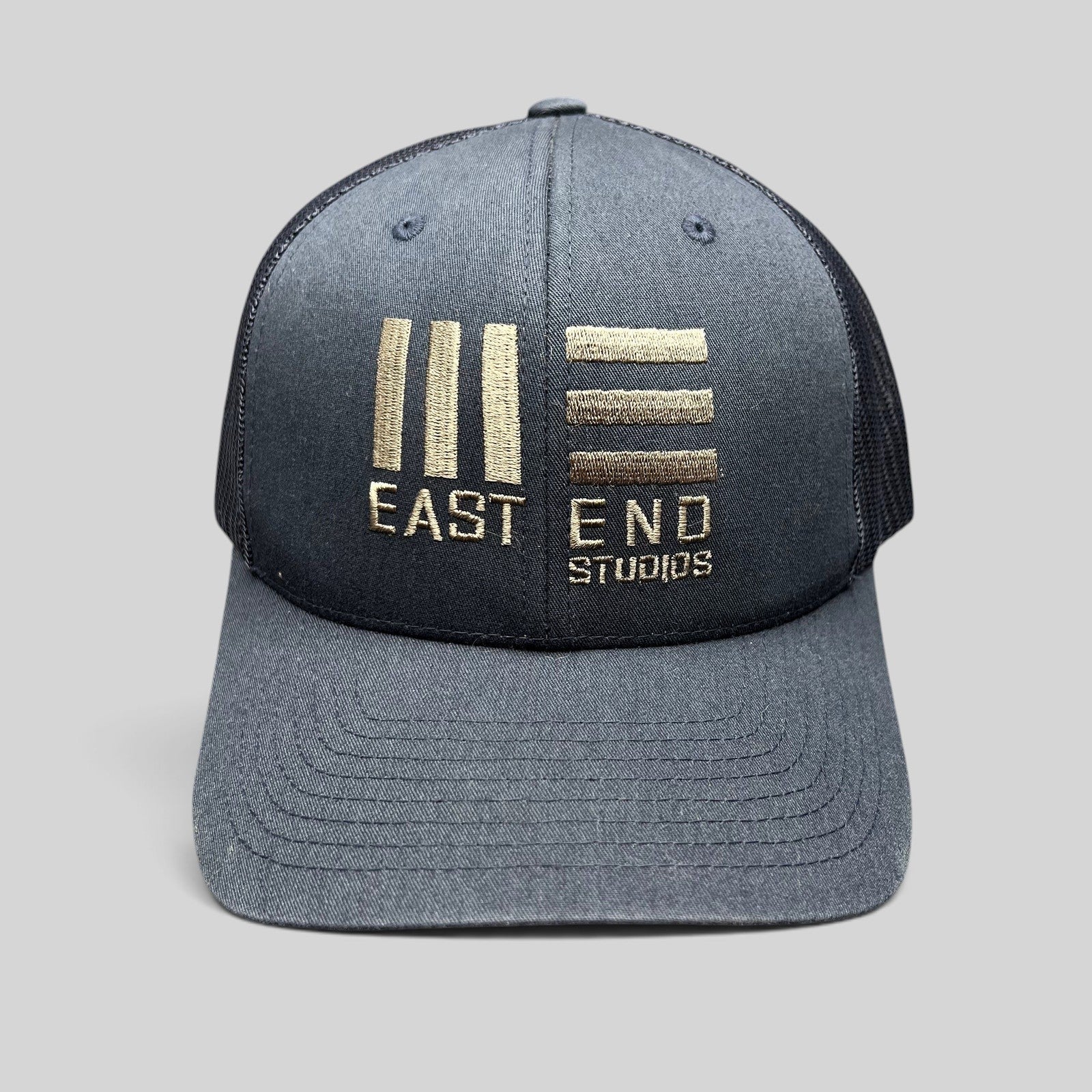 Raree Finds navy blue East End Studios trucker snapback hat with embroidered gold logo and breathable mesh back