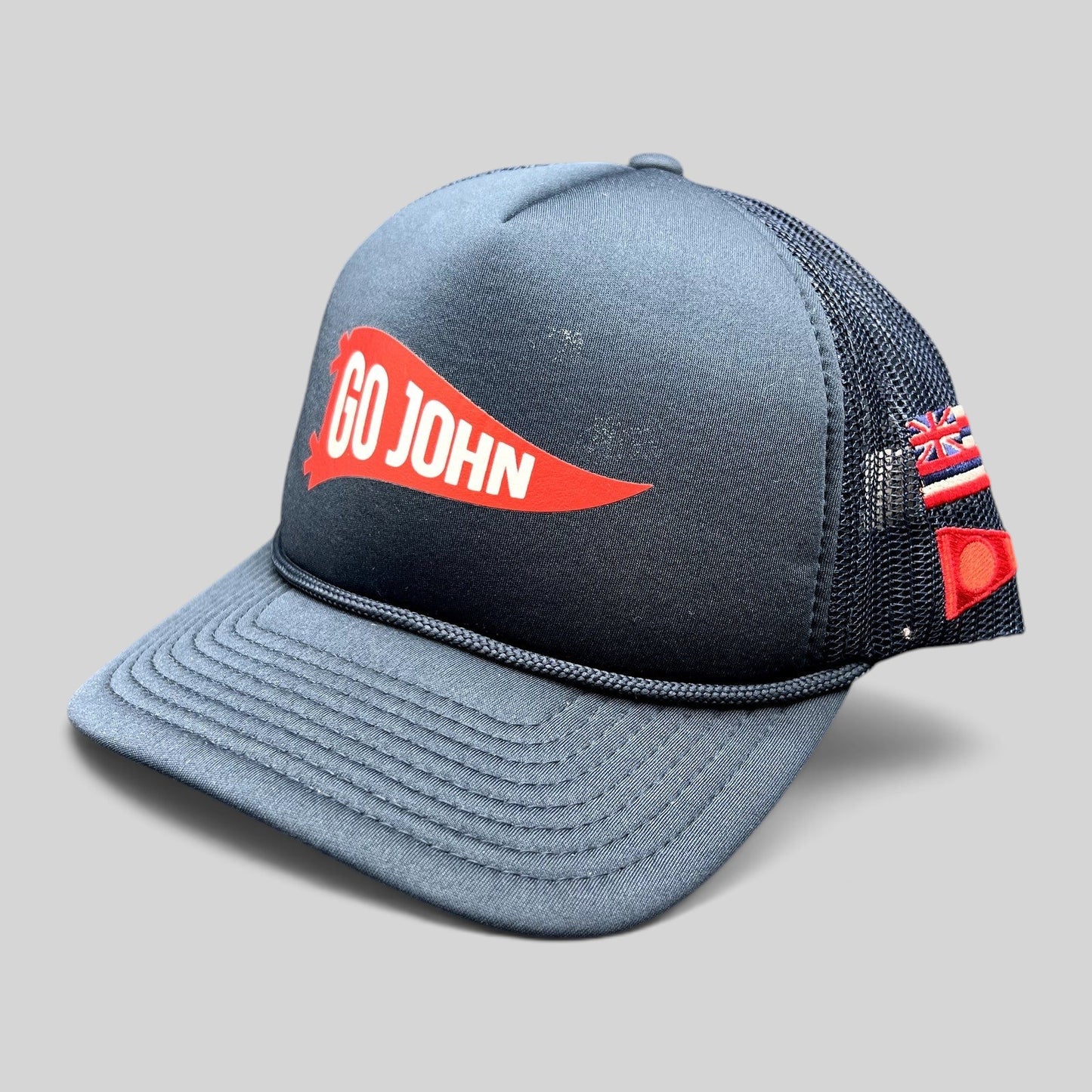 Raree Finds navy blue vintage trucker hat with red Go John pennant graphic, mesh back, and American flag side detail.