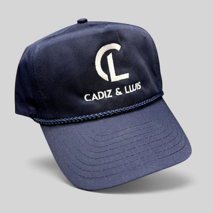 Raree Finds navy blue Cadiz & Lluis promotional snapback hat with white embroidered logo and braided rope bill detail