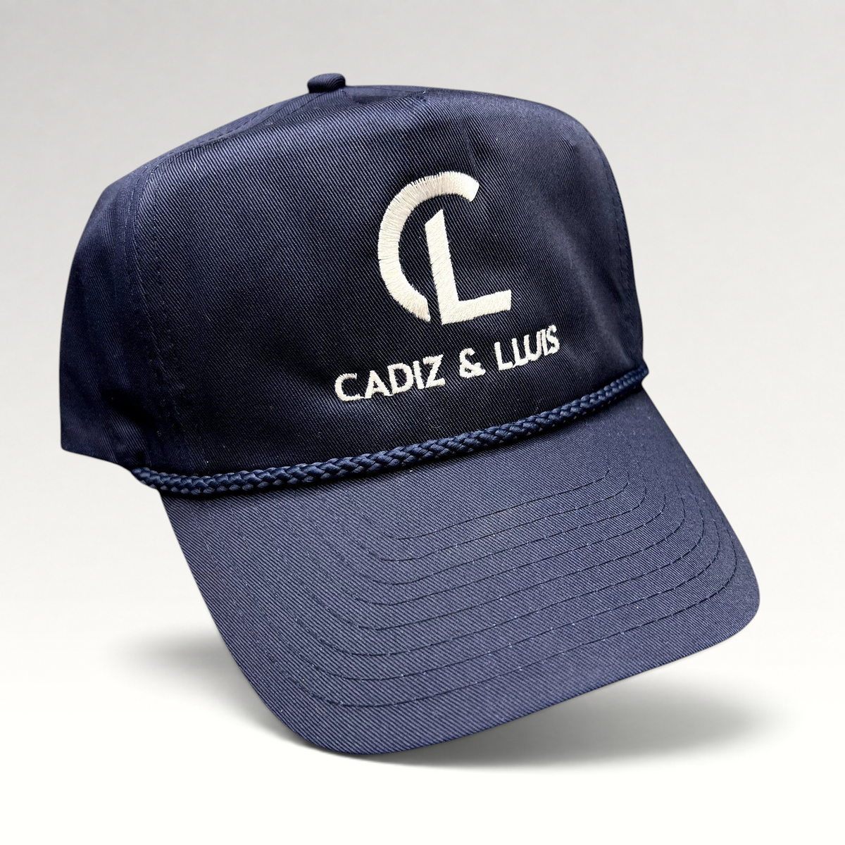 Raree Finds navy blue Cadiz & Lluis promotional snapback hat with white embroidered logo and braided rope bill detail