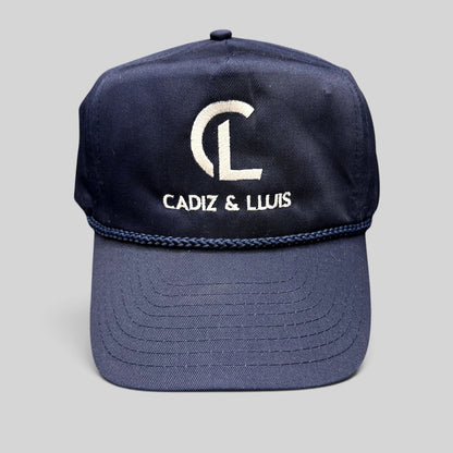 Raree Finds navy blue Cadiz & Lluis promotional snapback hat with white embroidered logo and braided rope bill detail