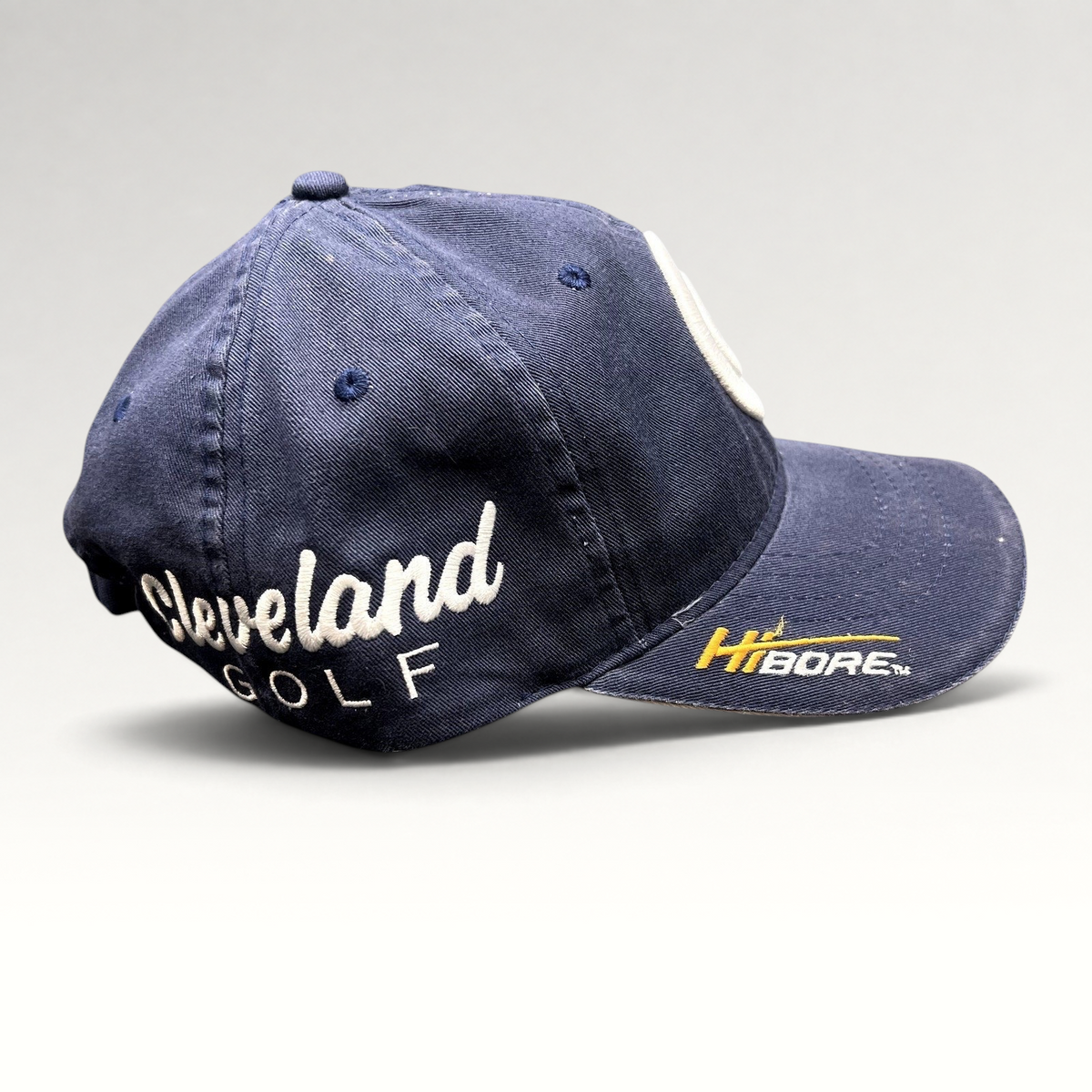 Raree Finds navy blue Cleveland Golf cotton twill strapback hat with side script embroidery and HiBore brim logo