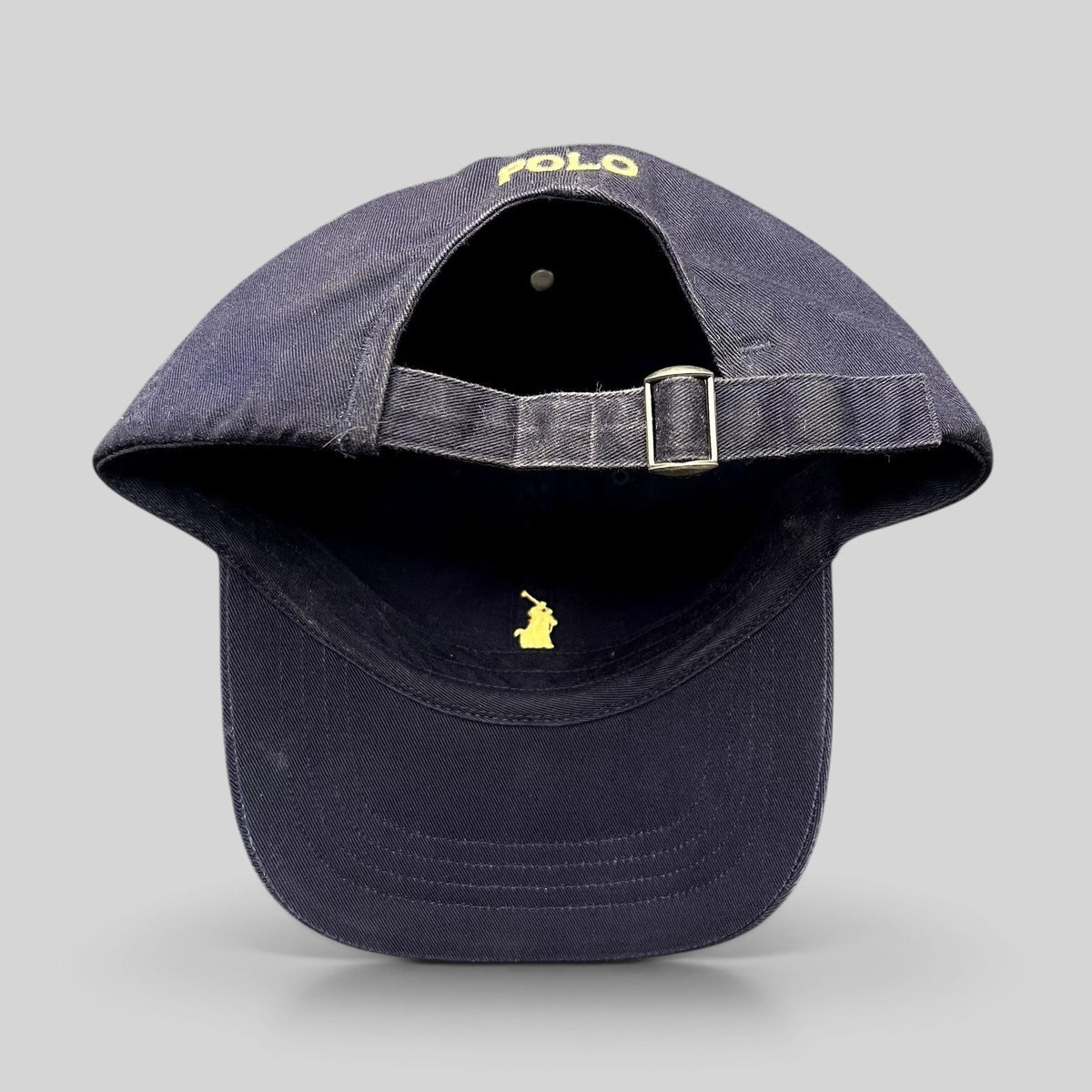 Raree Finds navy cotton chino baseball cap with yellow embroidered pony logo and adjustable brass buckle strapback