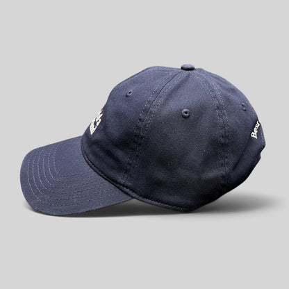 Raree Finds navy blue cotton twill dad hat with white embroidered text and curved brim, side profile view.