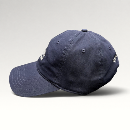 Raree Finds navy blue cotton twill dad hat with white embroidered text and curved brim, side profile view.