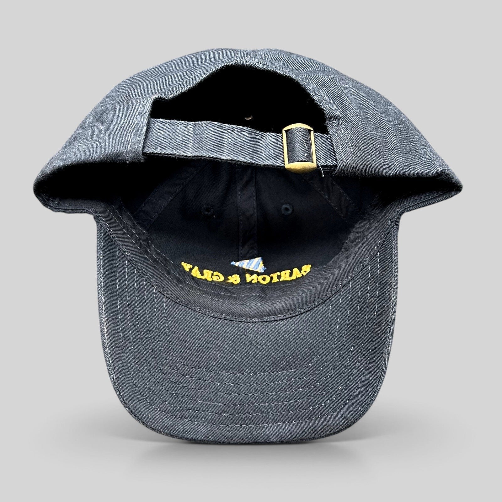 Raree Finds navy blue cotton strapback hat with adjustable brass buckle and embroidered logo detail