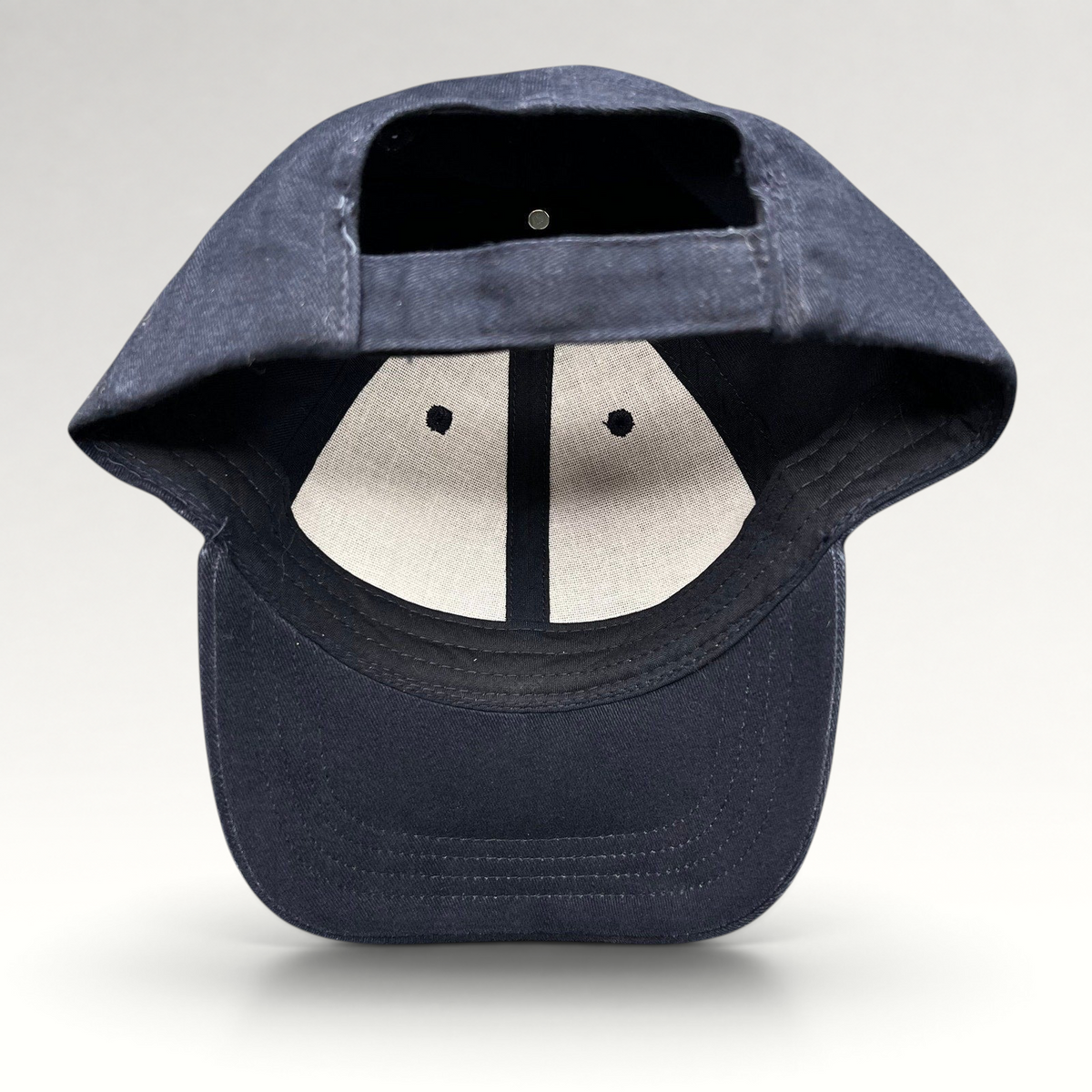 Raree Finds navy blue cotton strapback hat showing the interior lining and adjustable back strap