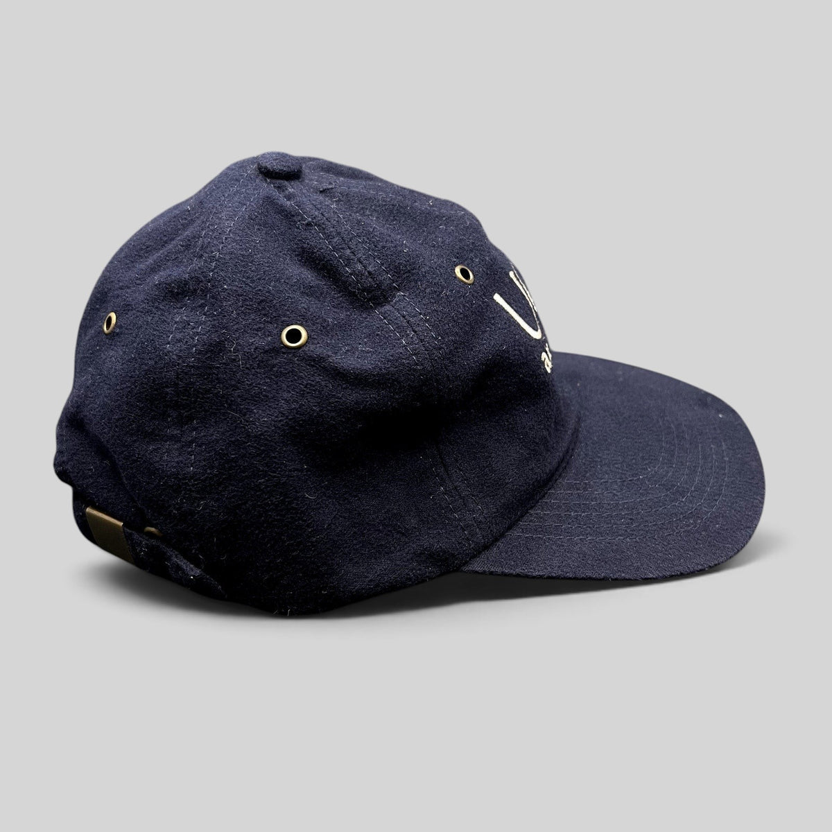 Raree Finds vintage navy blue cotton UGG Australia strapback hat with embroidered logo and brass buckle side view