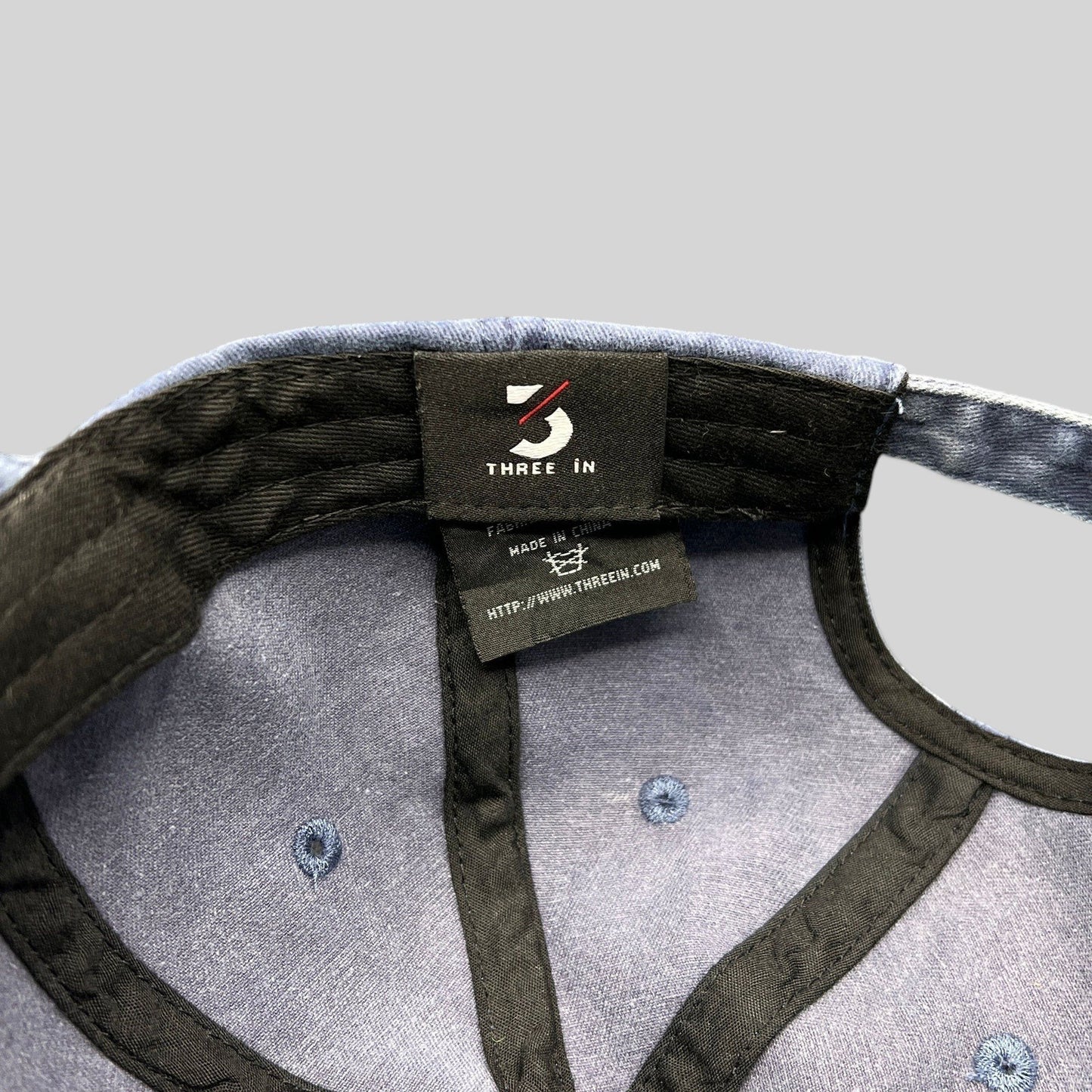 Raree Finds navy dad hat interior showing Three In brand label and stitching details