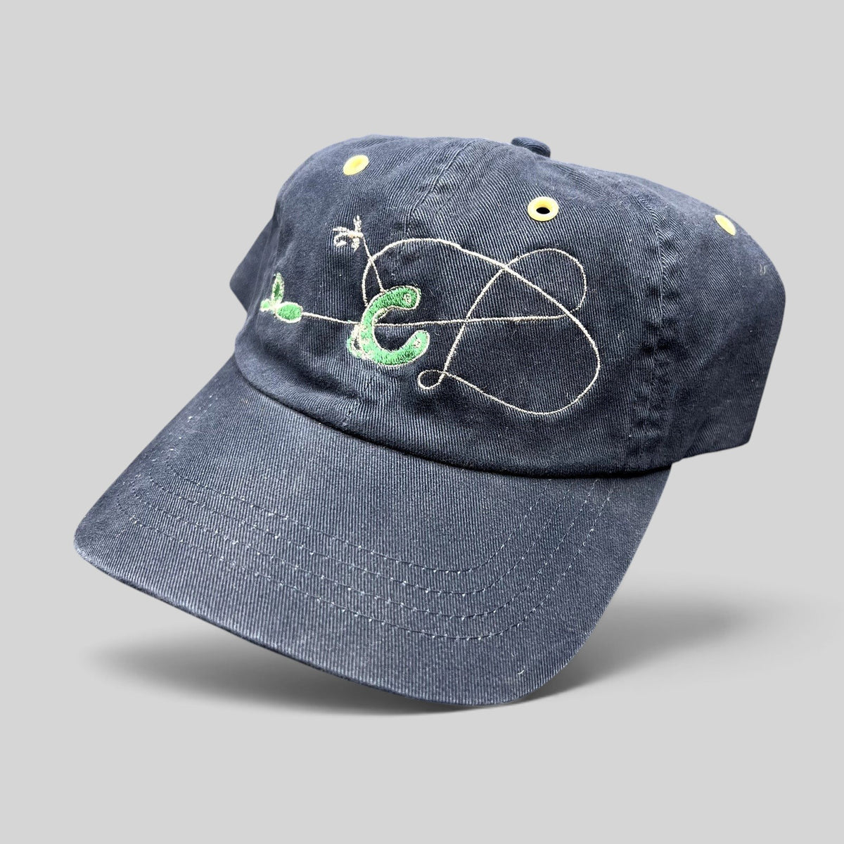 Raree Finds vintage navy cotton strapback hat with embroidered fly fishing lure design and yellow metal eyelets