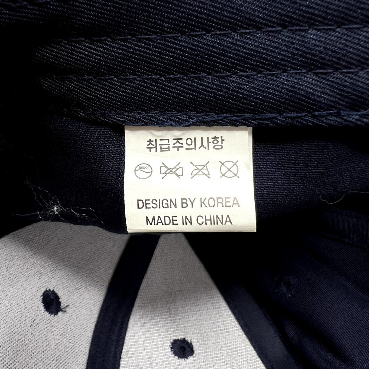 Raree Finds navy blue hat interior care label with Korean text and manufacturing details