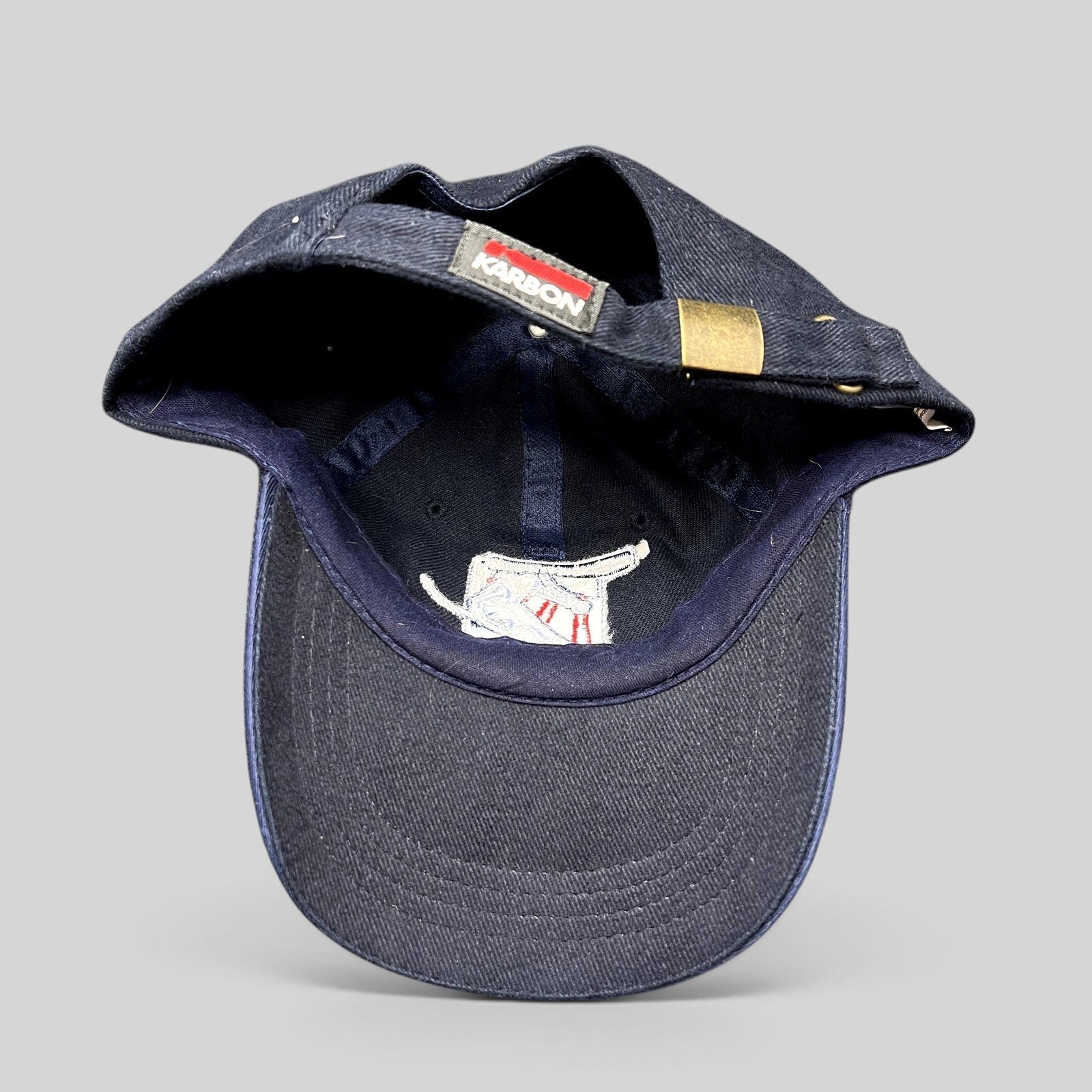 Raree Finds navy blue Karbon strapback hat with brass buckle and 2002 Aspen Winternational embroidered skier patch