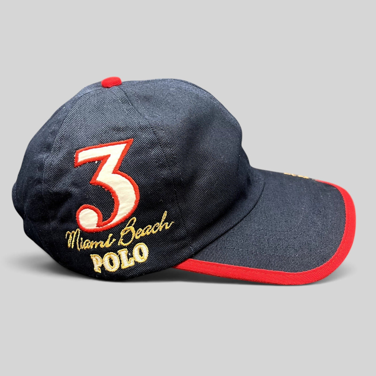 Raree Finds vintage navy blue La Martina cotton strapback hat with red brim piping and Miami Beach Polo embroidery.