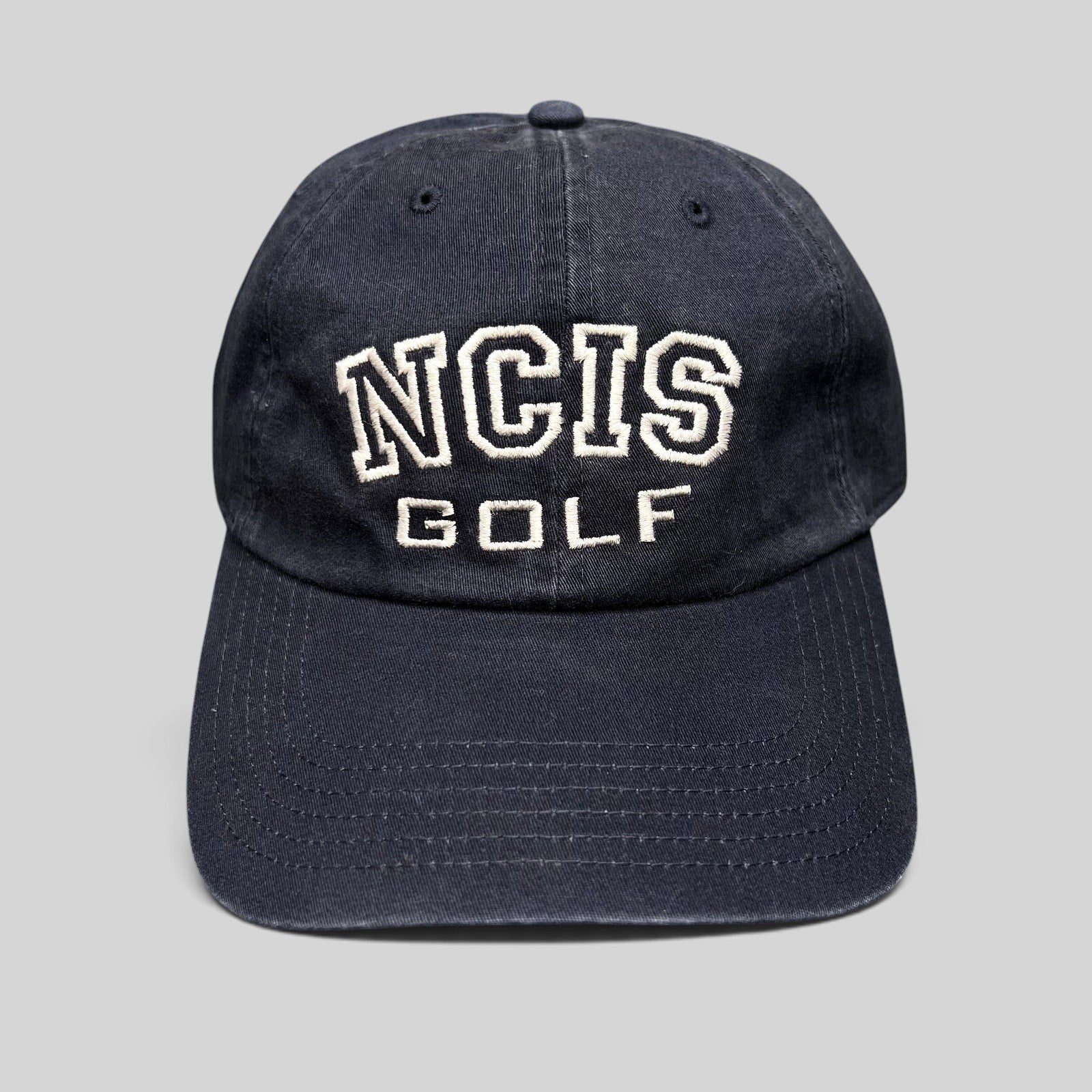 Raree Finds vintage navy blue NCIS Golf tournament strapback hat with white embroidered lettering on the crown.
