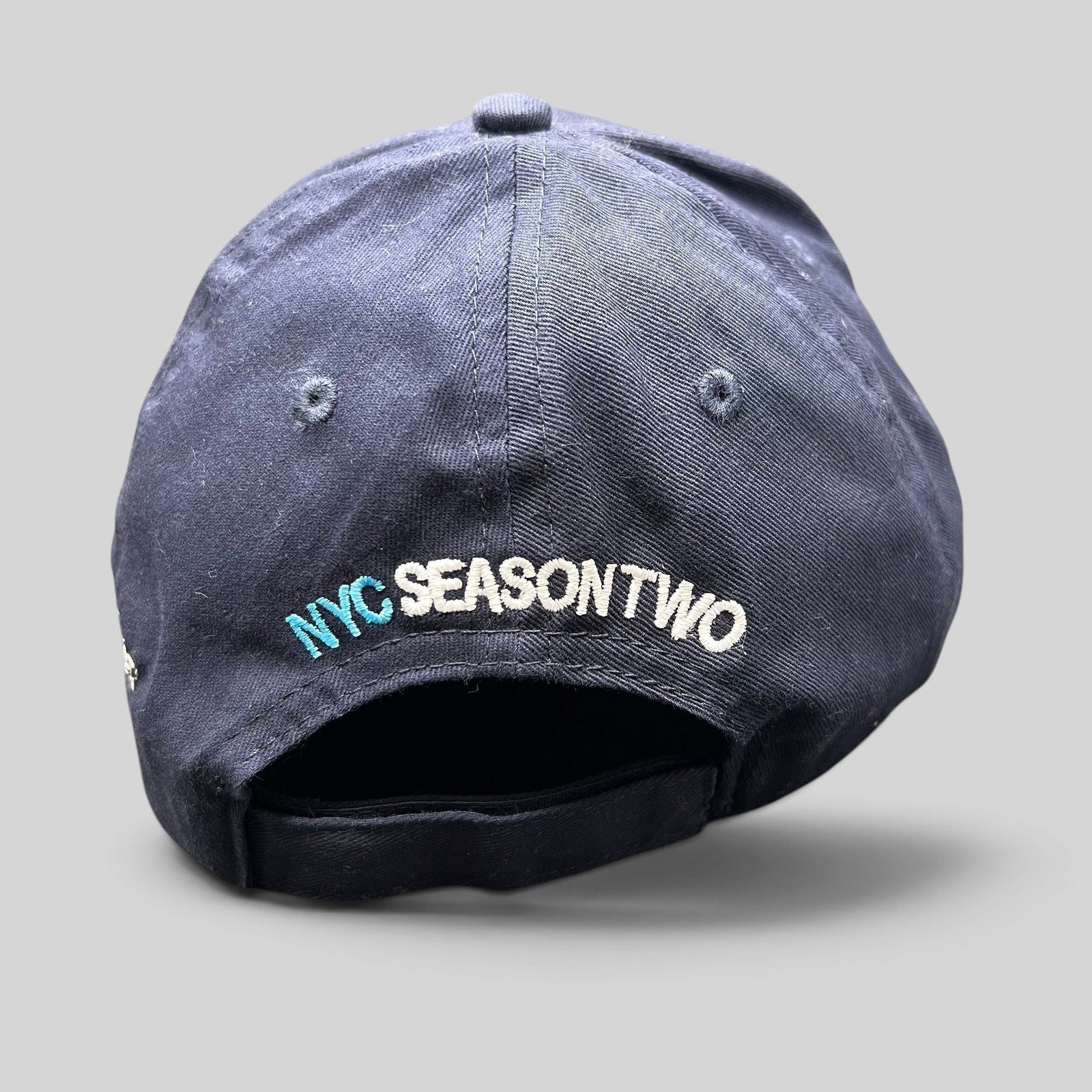 Raree Finds navy cotton strapback hat with NYC Season Two embroidery on the back, from God Friended Me production.