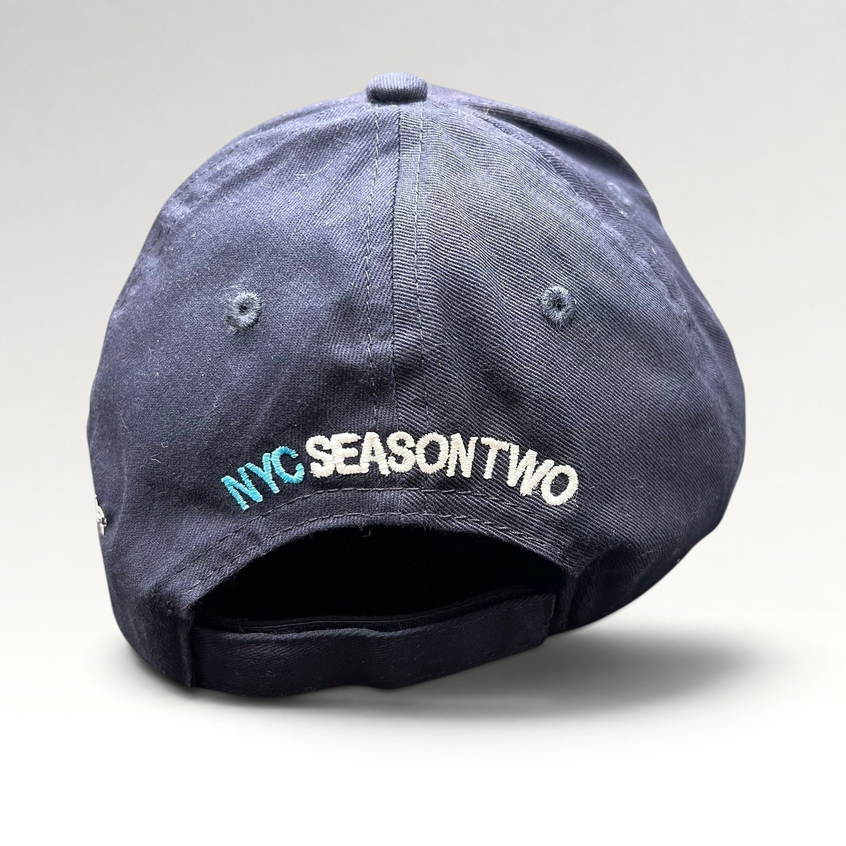 Raree Finds navy cotton strapback hat with NYC Season Two embroidery on the back, from God Friended Me production.